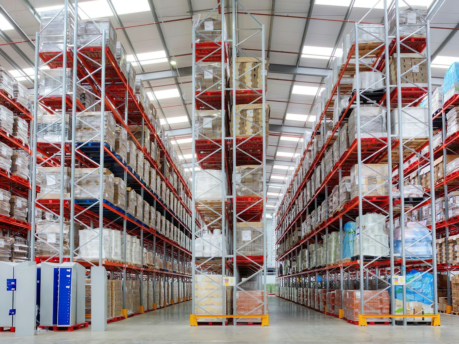 Corredor de um galpão de distribuição com estantes de paletes