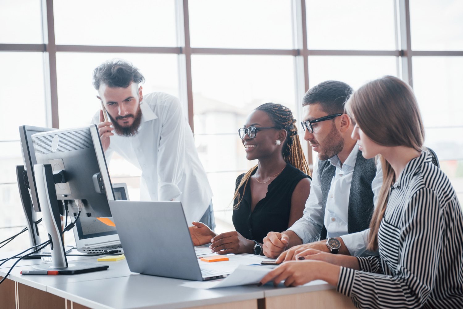 Equipe analisando dados de gestão em um computador