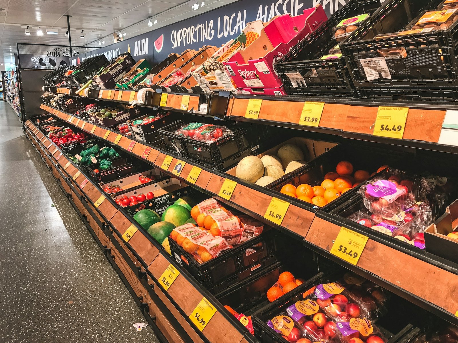 Corredor de hortifrúti de um mercado com frutas e legumes